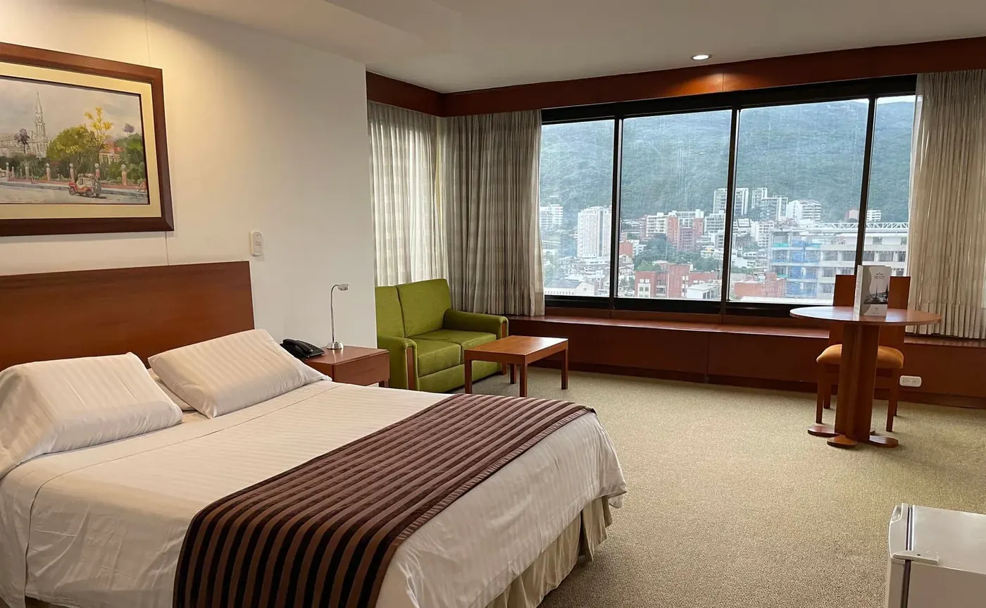 Habitación amoblada con ventanal panorámico sobre la ciudad
